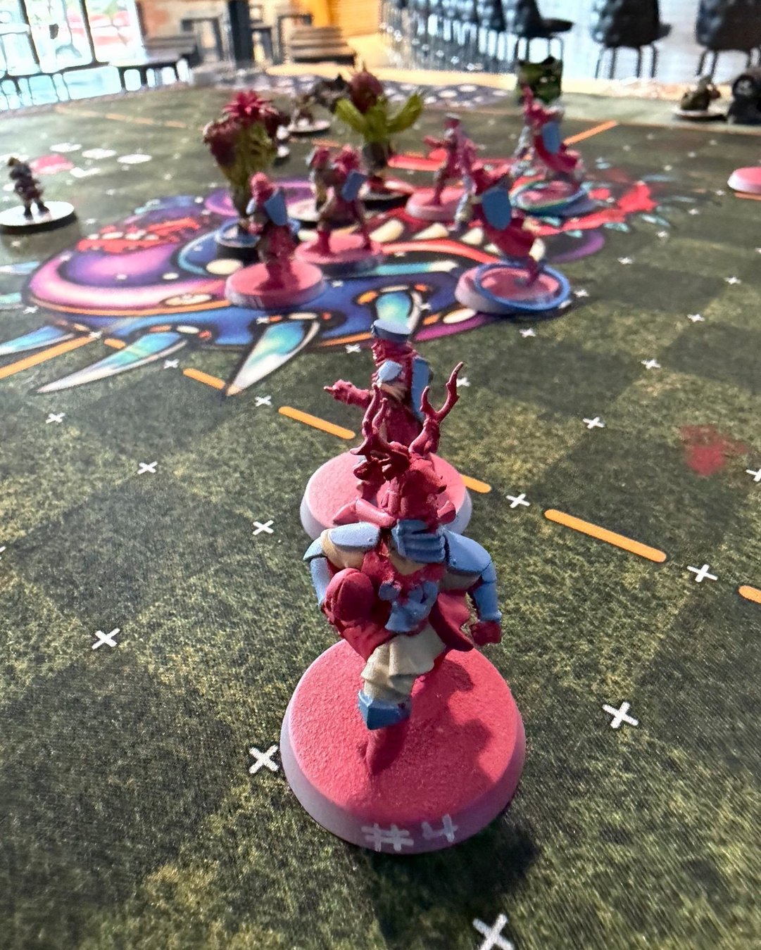 A Grenadiers knight on a pink base advancing up the pitch toward the halfling line
