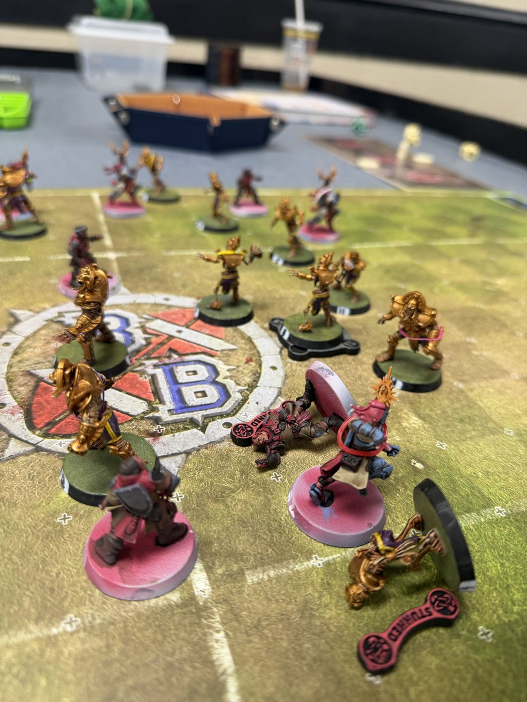 A Grenadiers knight standing over a Stunned Tomb Kings player, with the gold Tomb Guardians looming beyond