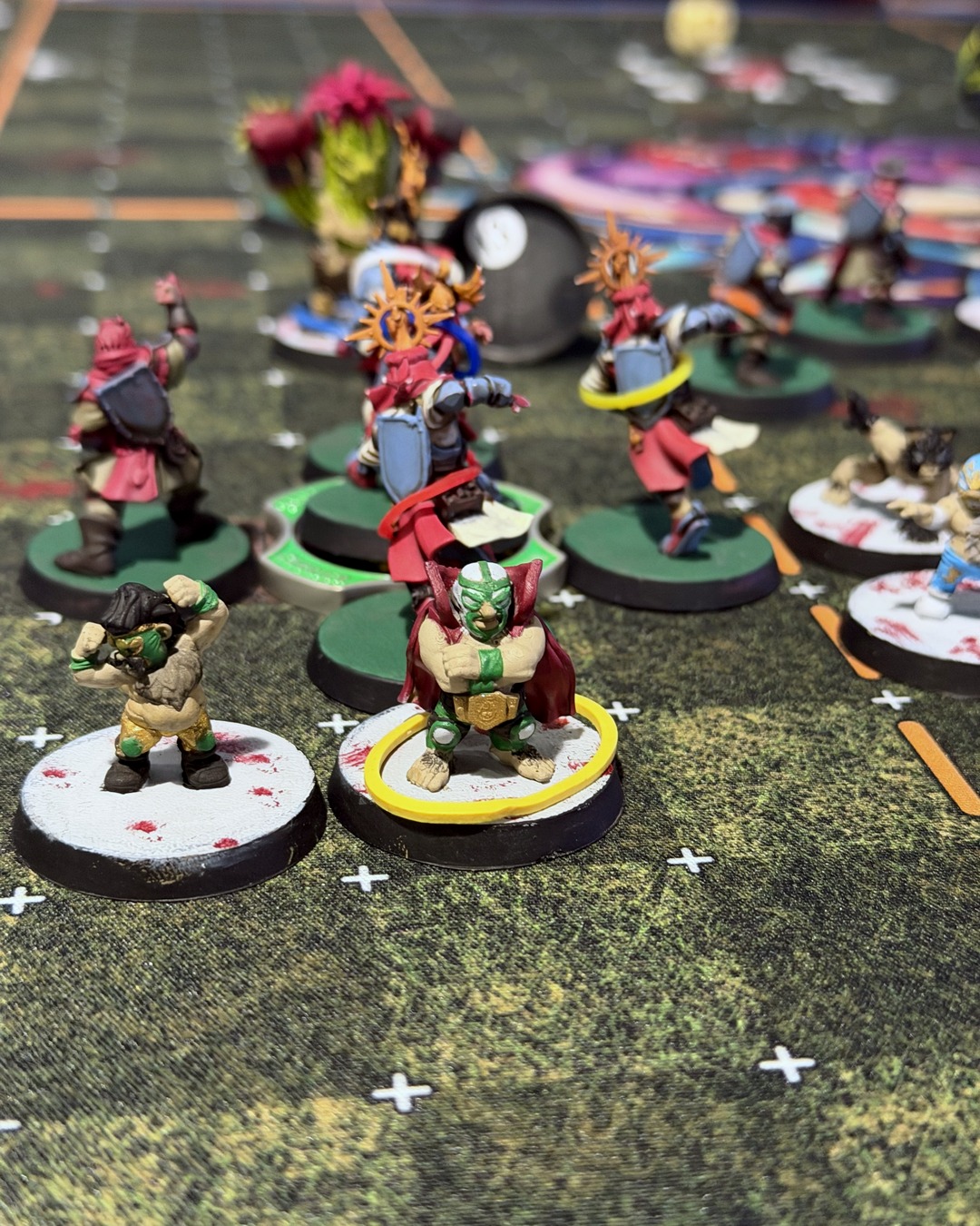 Two masked luchador halflings in green and gold in front of the Grenadier knights