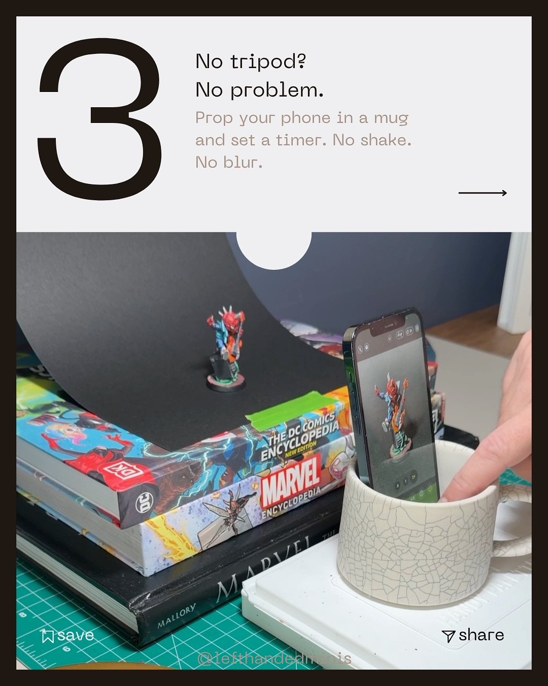 A phone propped in a ceramic mug pointed at the mini