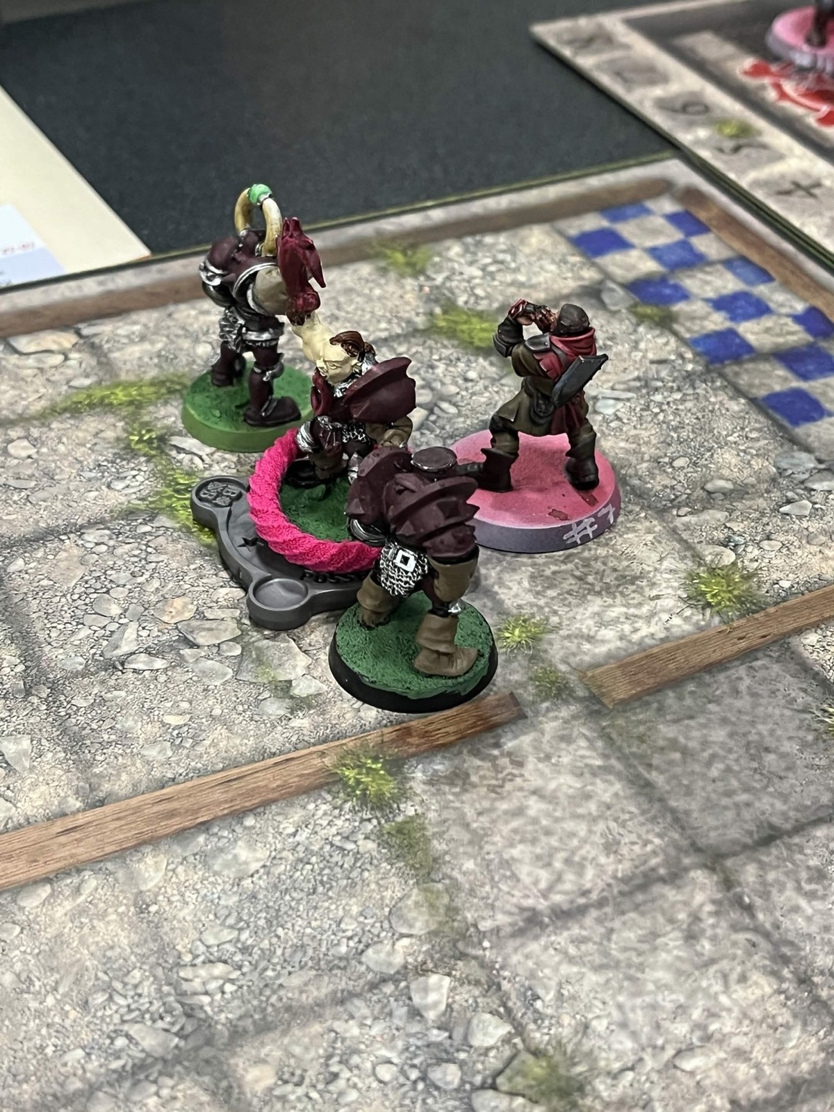Close-up of a Chaos Chosen player looming over a knocked-down Grenadier