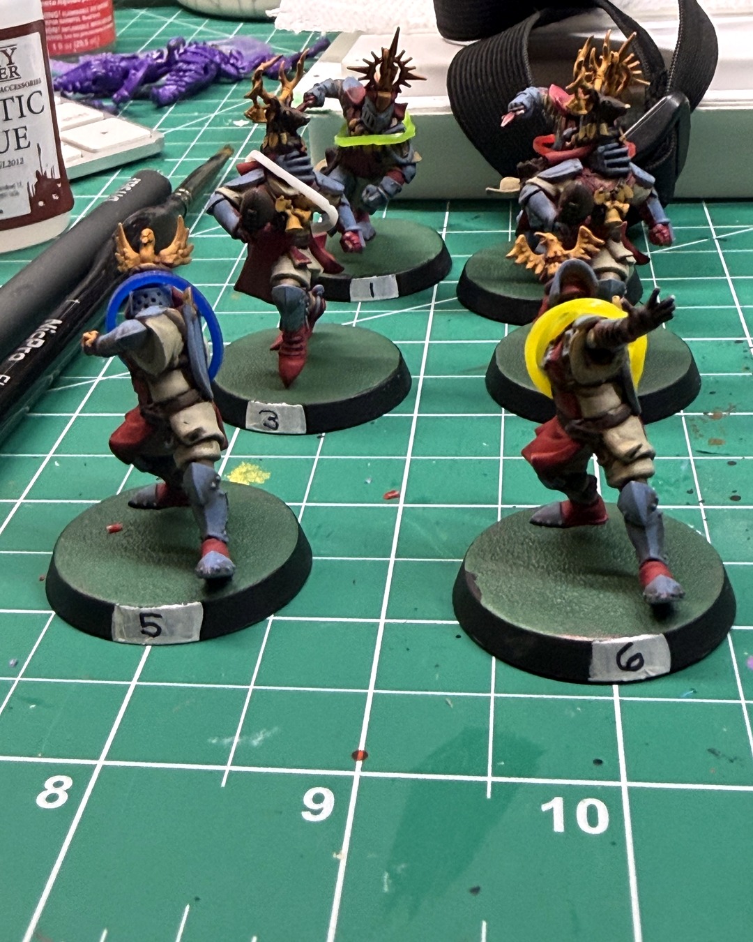 Holy Hand Grenadiers knights numbered 5 and 6 in focus on green bases with fresh white number labels on the black rims, knights 1 and 3 behind