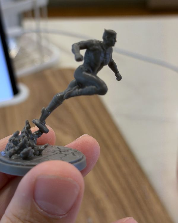 Unpainted Quicksilver mini held in hand, sprinting off one toe with a trail of debris rising from the base