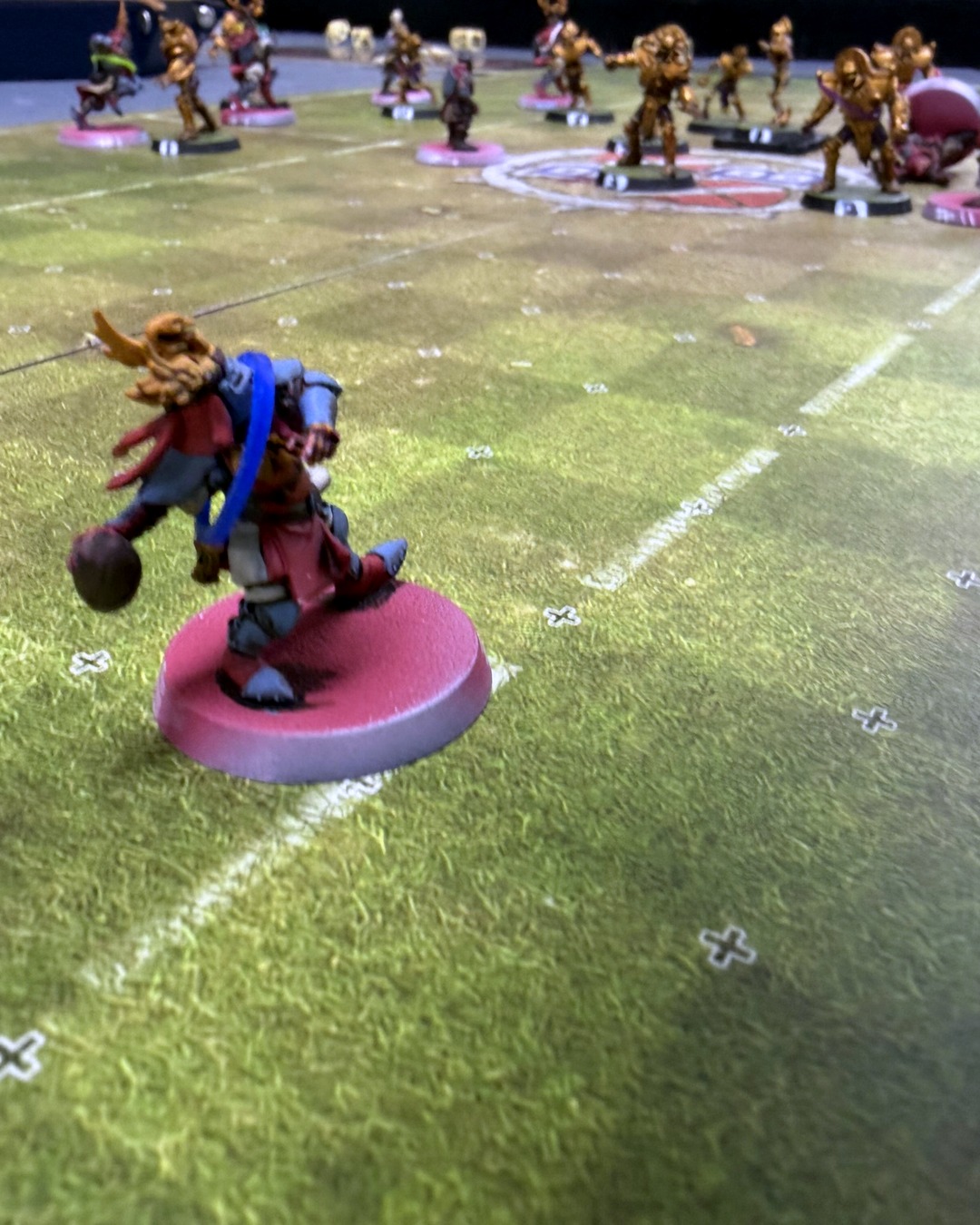 Low-angle shot of a Grenadiers catcher carrying the ball while the Tomb Kings wall holds midfield