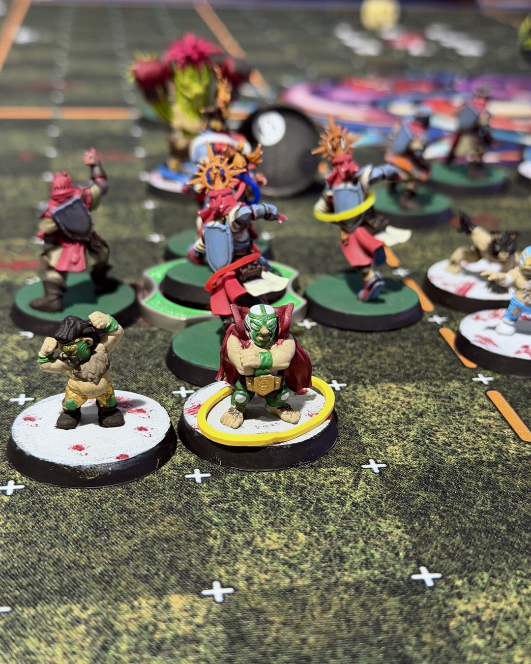 Two masked luchador halflings in green and gold in front of the Grenadier knights