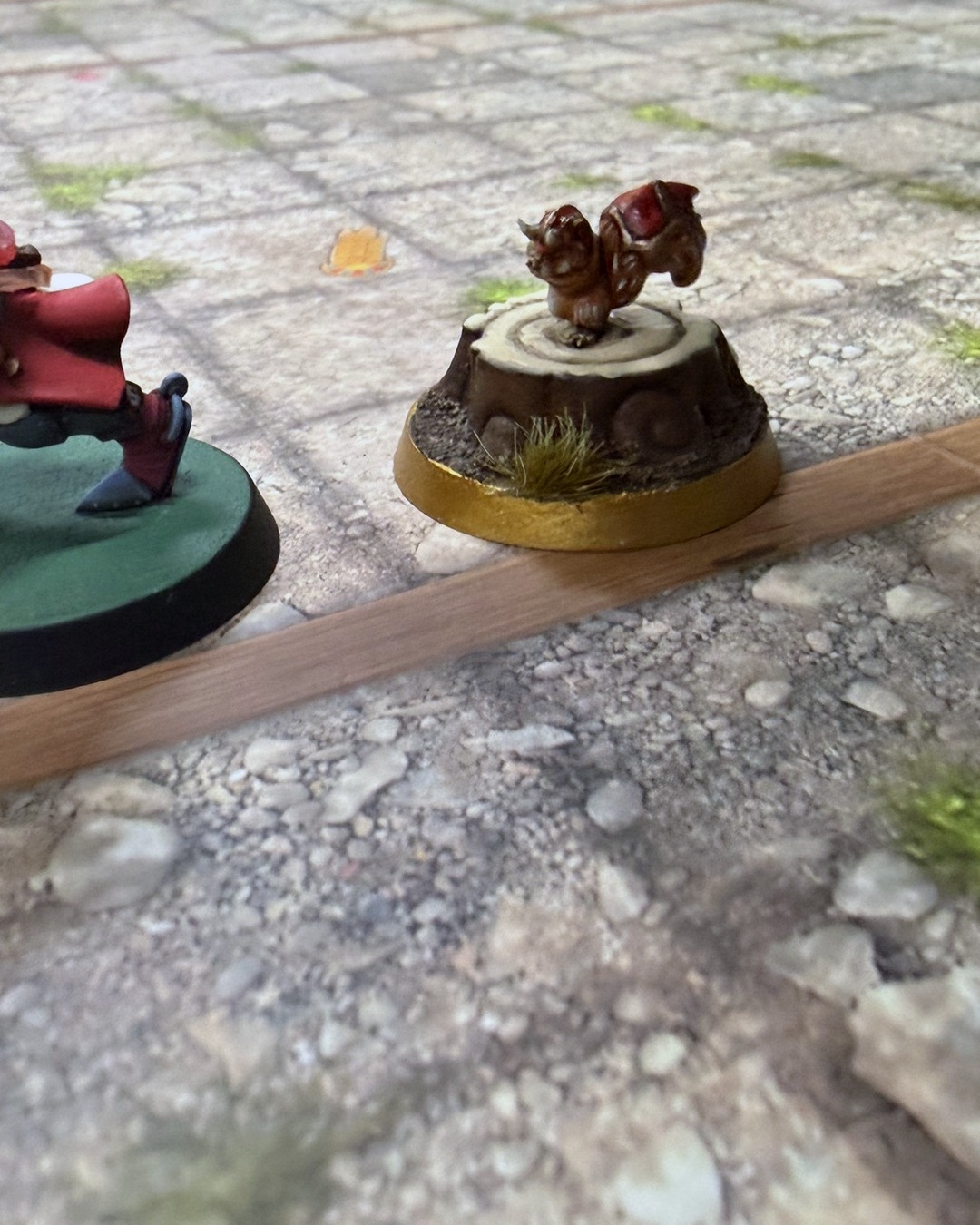 Close-up of Akhorne the Squirrel perched on his stump beside a Grenadier knight