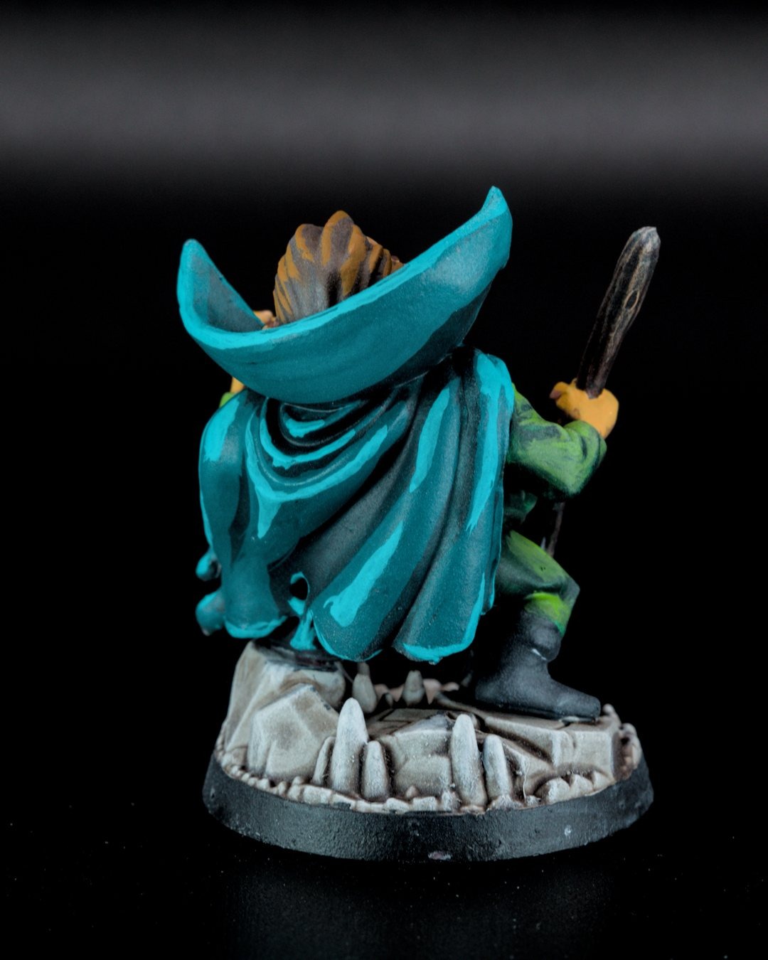 Mole Man from behind, cape sweeping over a rocky base