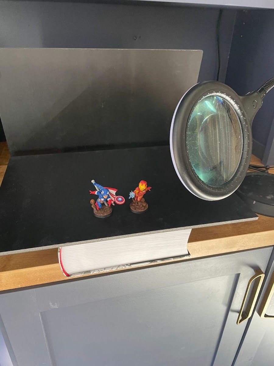 An early setup with a dark curved backdrop on a counter and a lamp